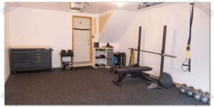 Välutrustat hemmagym med skivstång, bänk, kettlebells och träningsband