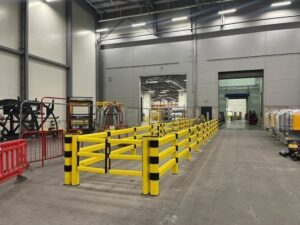 Gula påkörningsbarriärer skyddar lagergångar i en industrihall