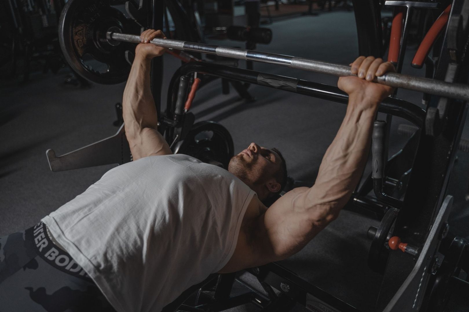 Person tränar bänkpress med skivstång på gym